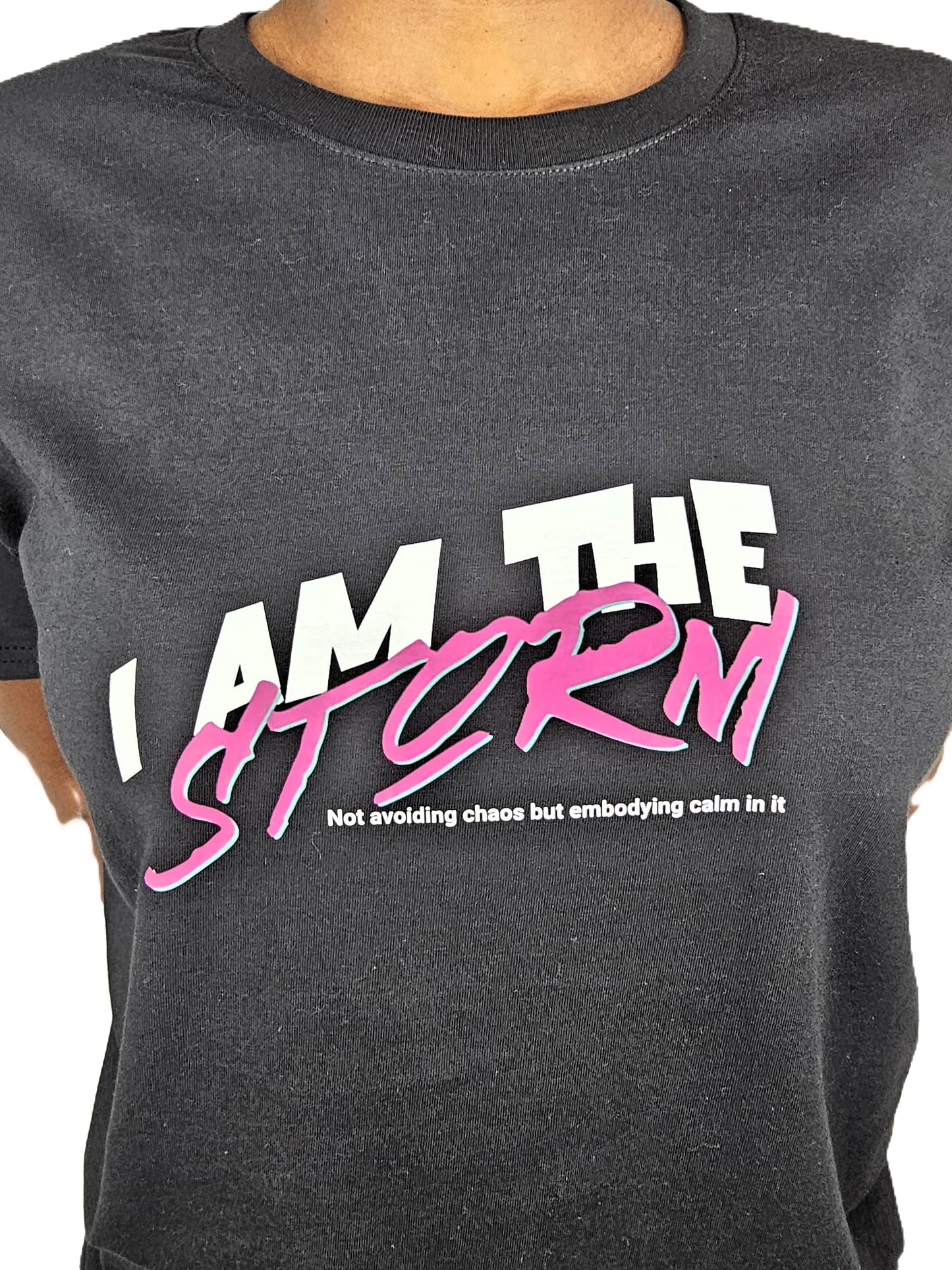 Black t-shirt with 'I AM THE STORM' text in white and pink on a plain background
